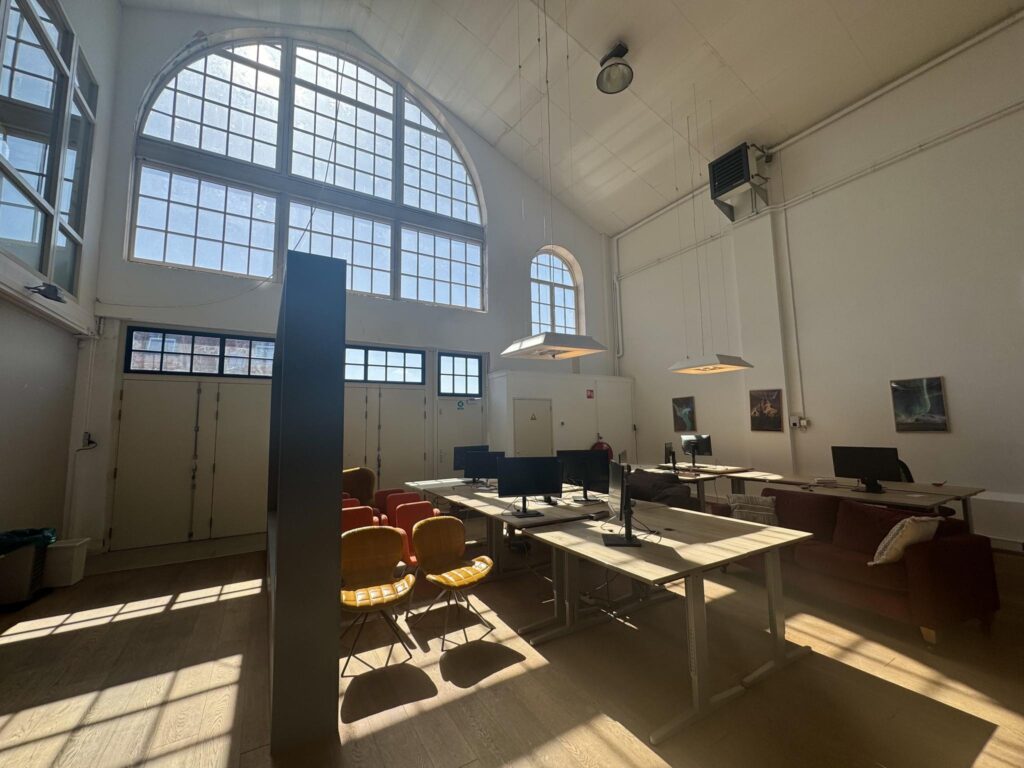 Ruim en licht kantoor in het Gedempt Hamerkanaal met hoge ramen en industriële inrichting.